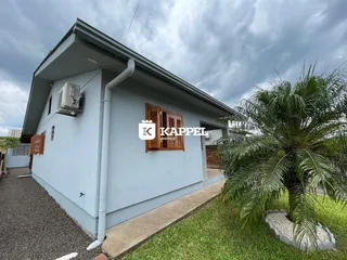 Fachada externa de uma casa em Lajeado, Brasil, com jardim gramado e calçada.