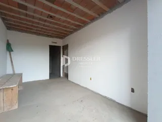 Espaço interno com teto de madeira aparente e paredes brancas.