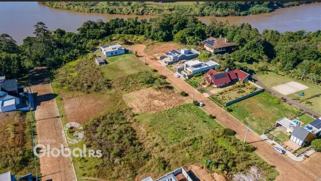 Vista aérea de um terreno com vegetação ao redor e uma faixa de rio.