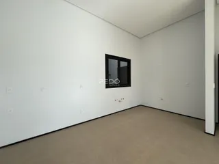 Foto de um cômodo interno com paredes brancas e piso claro.