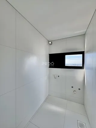 Um corredor moderno com paredes brancas e piso claro.