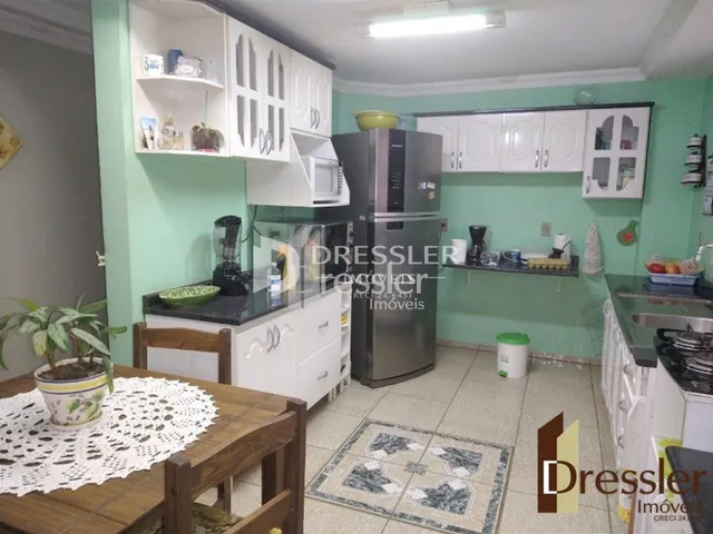 Foto de uma cozinha com armários brancos e piso cerâmico.