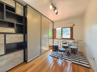 Ambiente interno com piso de madeira e portas de correr na sala de um imóvel em Lajeado.