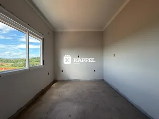 Foto de um cômodo vazio com janela mostrando a paisagem externa.