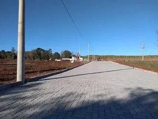 Uma estrada pavimentada se estende por um campo aberto.