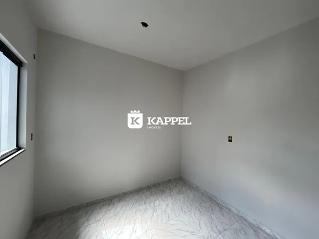 Foto de um cômodo interno com paredes brancas e piso de mármore claro.