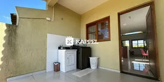 Esta é uma foto interna de uma sala com paredes amarelas e um armário branco.