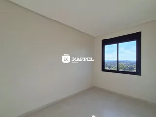Ambiente interno de um cômodo com grande janela mostrando a paisagem.