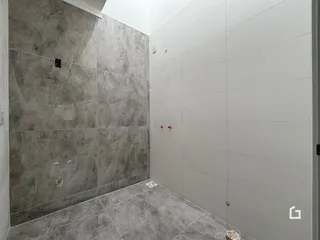 Parede e piso de um ambiente interno em tom de cinza claro.
