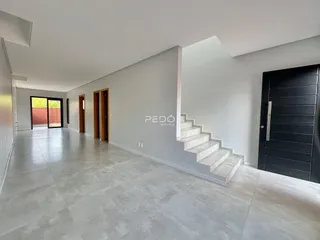 Hall de entrada com piso de cerâmica claro e portas de madeira.