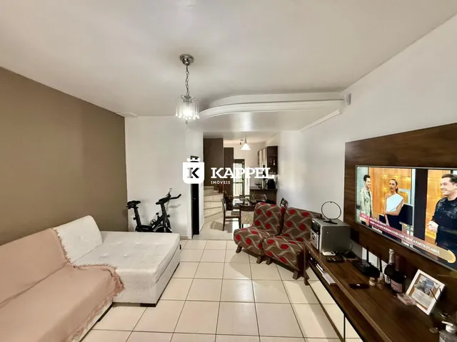 Sala de estar com sofá e televisão em um ambiente interno.