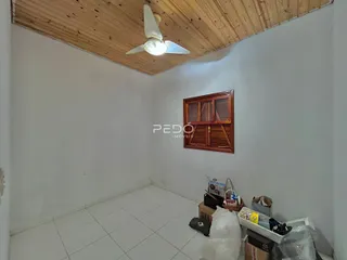 Interior de um cômodo com teto de madeira e piso de cerâmica.