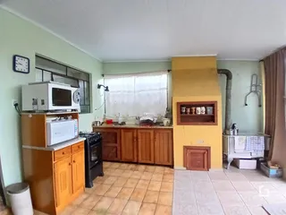 Foto de uma cozinha com armários de madeira e piso cerâmico.