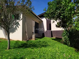 Vista da fachada de uma casa em Lajeado com jardim gramado.