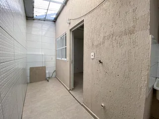 Um corredor interno com paredes texturizadas e piso de cerâmica.