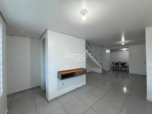 Hall de entrada com piso de cerâmica e escadaria visível.