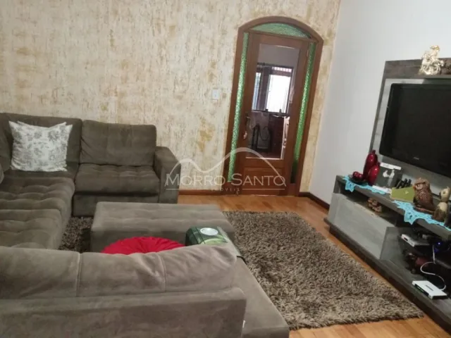 Sala de estar com sofá grande e parede texturizada.