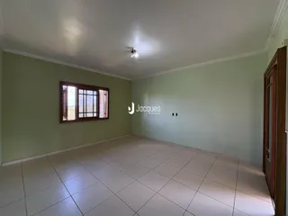 Sala com piso de cerâmica e janela de madeira.