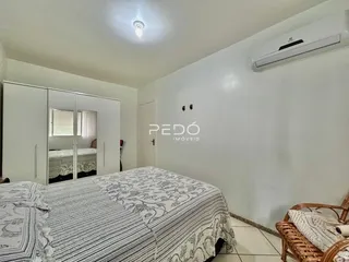 Quarto com cama e armários brancos em um imóvel no Brasil.