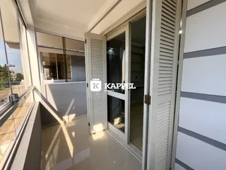 Sala de estar com grandes janelas e vista para o exterior.