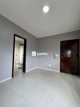 Hall de entrada com piso de cerâmica e parede cinza na propriedade.