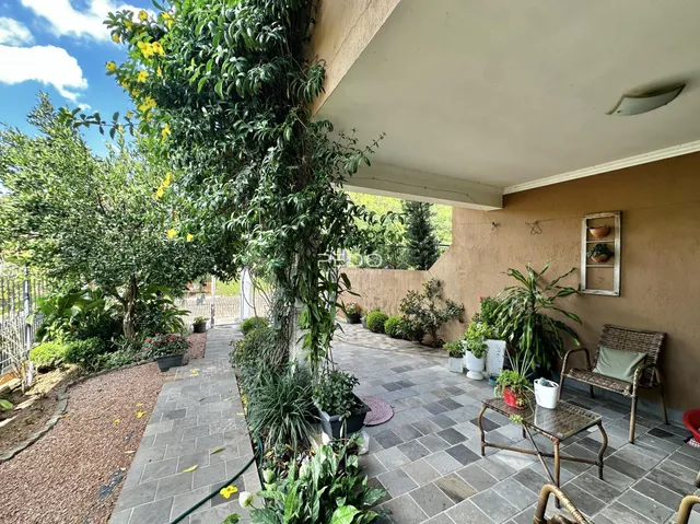 Vista da fachada com jardim e área externa de uma residência em Lajeado.