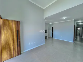 Hall com porta de madeira e paredes cinzas claras.