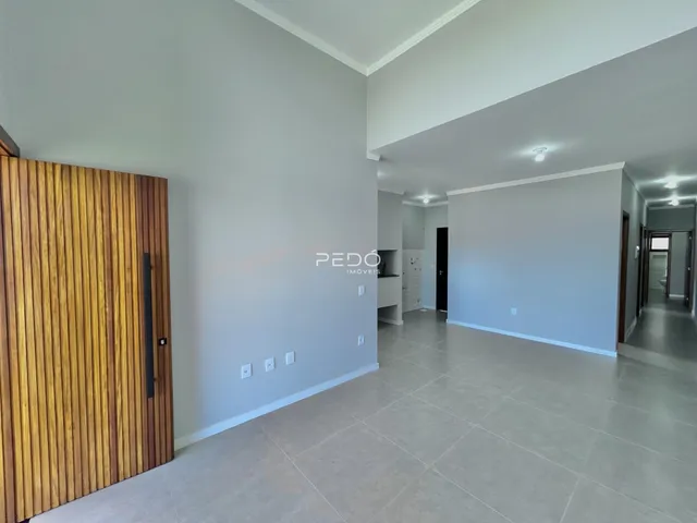 Hall com porta de madeira e paredes cinzas claras.