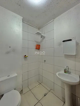 Foto interna de um banheiro com revestimento cerâmico nas paredes e piso.