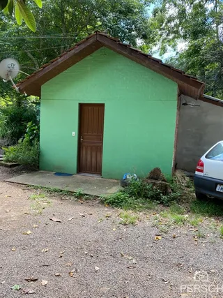 Fachada externa de uma construção verde em Lajeado, Brasil, com porta de madeira.