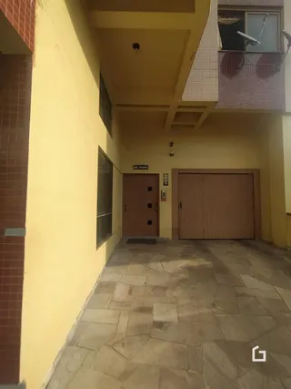 Hall de entrada com piso de cerâmica e parede amarela na propriedade.