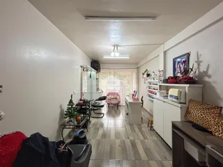 Interior de uma sala de estar com piso de madeira clara e paredes brancas.