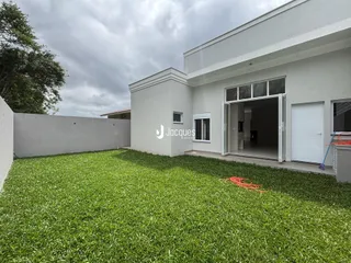 A fachada moderna de uma residência em Lajeado, Brasil, com um grande gramado verde.