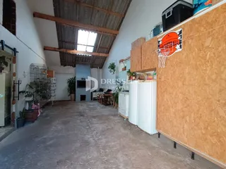 Interior de um espaço amplo com teto alto e vigas de madeira expostas.