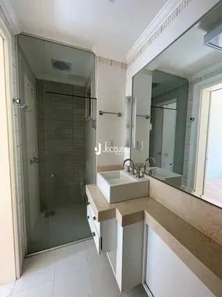 Foto de um banheiro moderno com box de vidro e bancada de mármore.