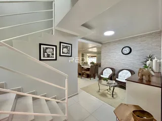 Interior de uma sala com escadaria e decoração moderna.