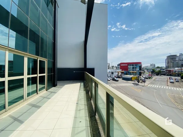 Vista de uma varanda moderna com piso de cerâmica e grade de vidro.