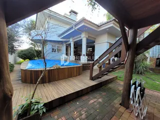A fachada da casa em Lajeado, Brasil, mostra a área externa com piscina e deck de madeira.