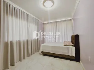 Quarto com cama e cortinas brancas.