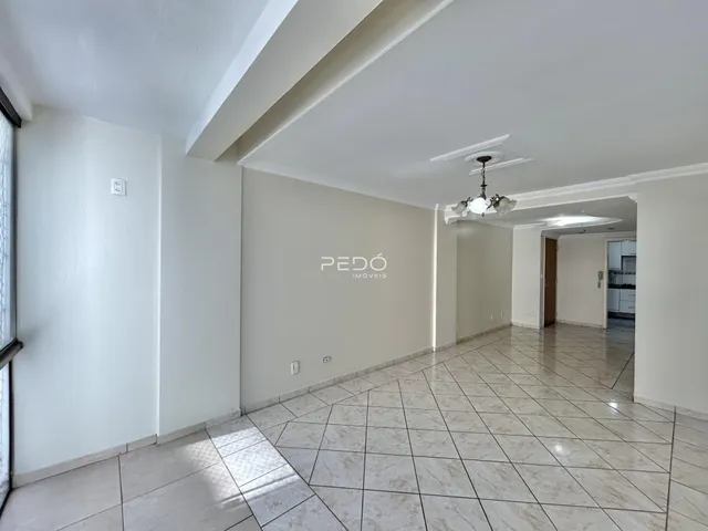 Corredor com piso de cerâmica e paredes brancas.