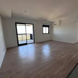 Foto de uma sala de estar com piso de madeira clara e janelas.