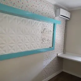 Parede interna com papel de parede texturizado e moldura azul clara.