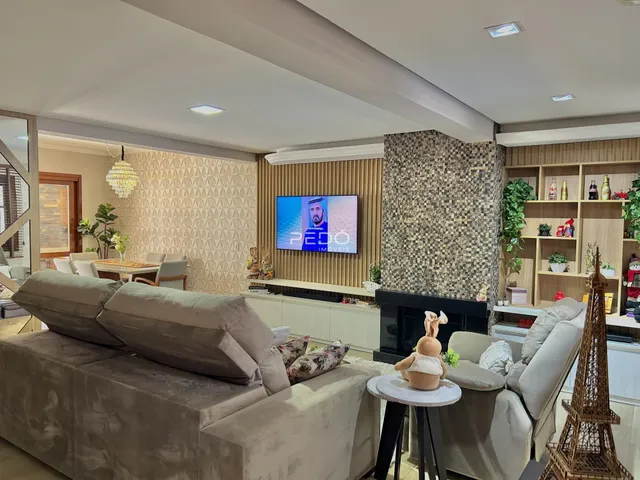 Sala de estar moderna com sofá grande e lareira em um imóvel no Brasil.