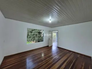 Sala de estar com piso de madeira e grande janela.