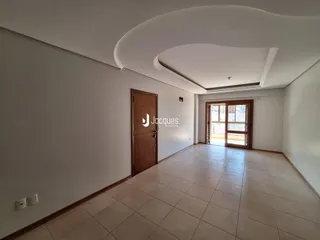 Hall de entrada com piso de cerâmica e porta de madeira em um imóvel em Lajeado.