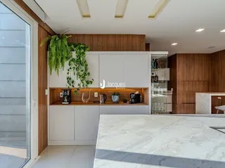 Interior de uma sala com armários brancos e detalhes em madeira