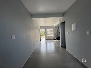 Corredor interno de uma residência com piso de cerâmica.