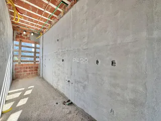 corredor interno com parede de tijolo aparente e teto exposto