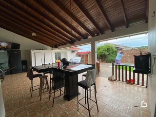 Foto de uma área de jantar coberta com piso de cerâmica e vista para o quintal.