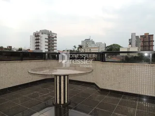 Vista de uma varanda com piso de cerâmica e grade de segurança.